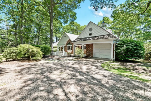 a view of a house with a yard and large tree