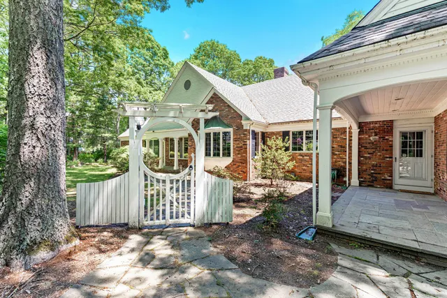 a view of a house with a small yard and wooden fence