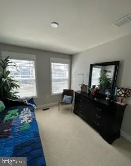 a spacious bedroom with a bed window and table