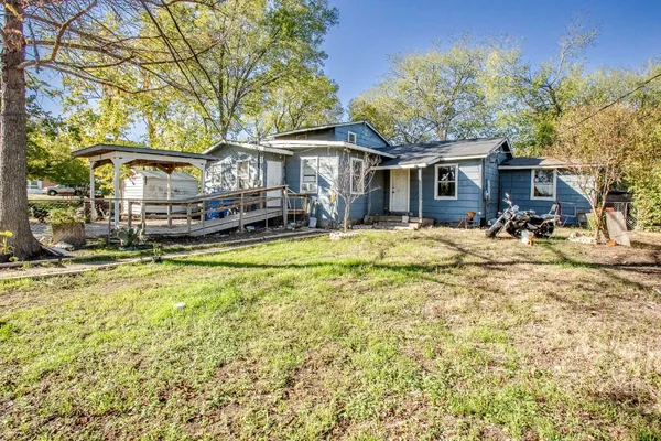 a view of a house with a yard patio and fire pit