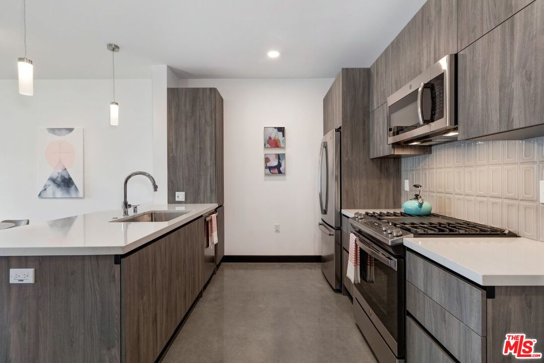 11036 Moorpark Street, Unit PH18 Los Angeles, CA 91602 - Photo 13 of 22 a kitchen with stainless steel appliances granite countertop a sink stove and refrigerator