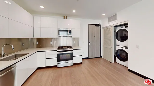 a kitchen with stainless steel appliances a stove a sink a refrigerator and cabinets