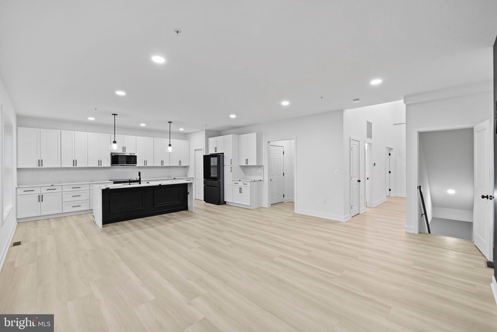 235 Brock Bridge Road Laurel, MD 20724 - Photo 24 of 59 a large white kitchen with kitchen island a sink a stove and a refrigerator