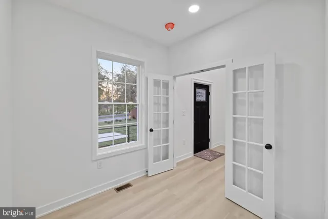 an empty room with windows and cabinet