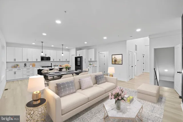 a living room with furniture and a view of kitchen