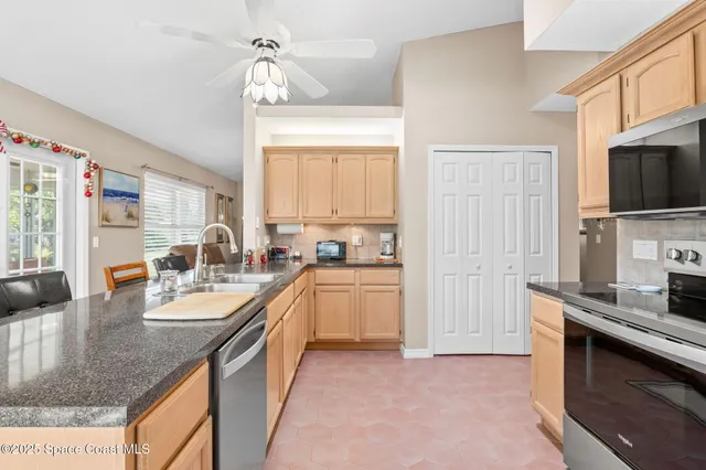 a kitchen with granite countertop a sink a counter top space appliances and cabinets