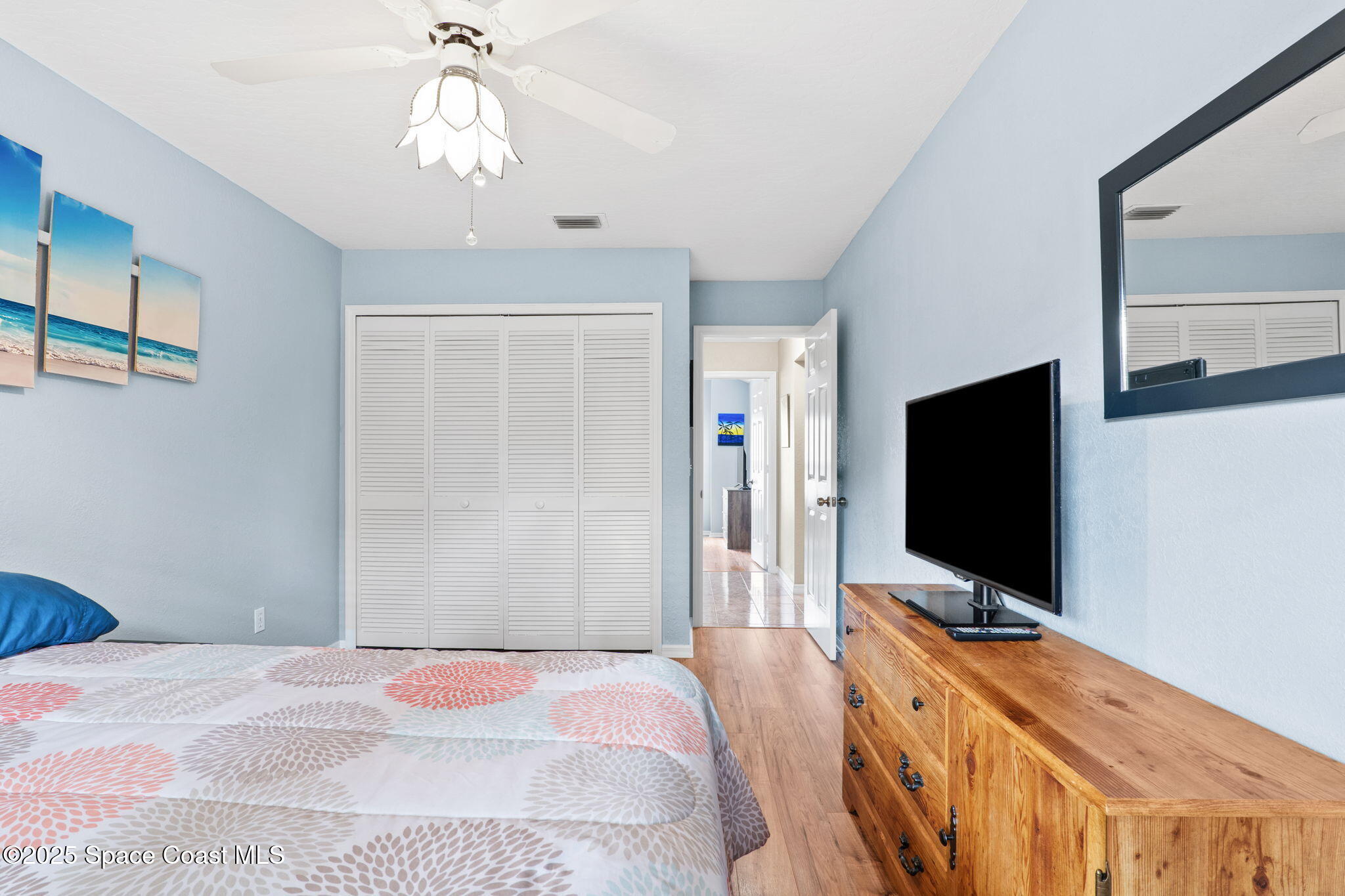 441 Southwest Avocado Avenue Sebastian, FL 32958 - Photo 9 of 30 a bedroom with a flat screen tv and a chandelier