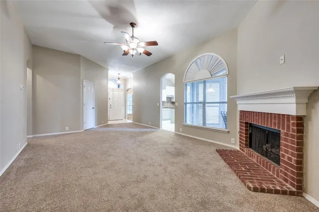 a view of an empty room with a chandelier fan