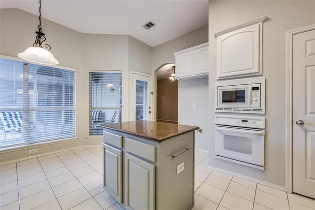 a kitchen with white cabinets and appliances