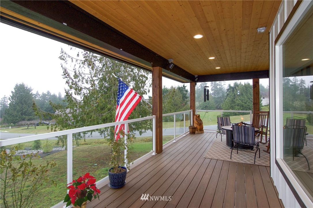 55 Ravens Ridge Road Sequim, WA 98382 - Photo 15 of 40 a balcony with wooden floor and outdoor seating