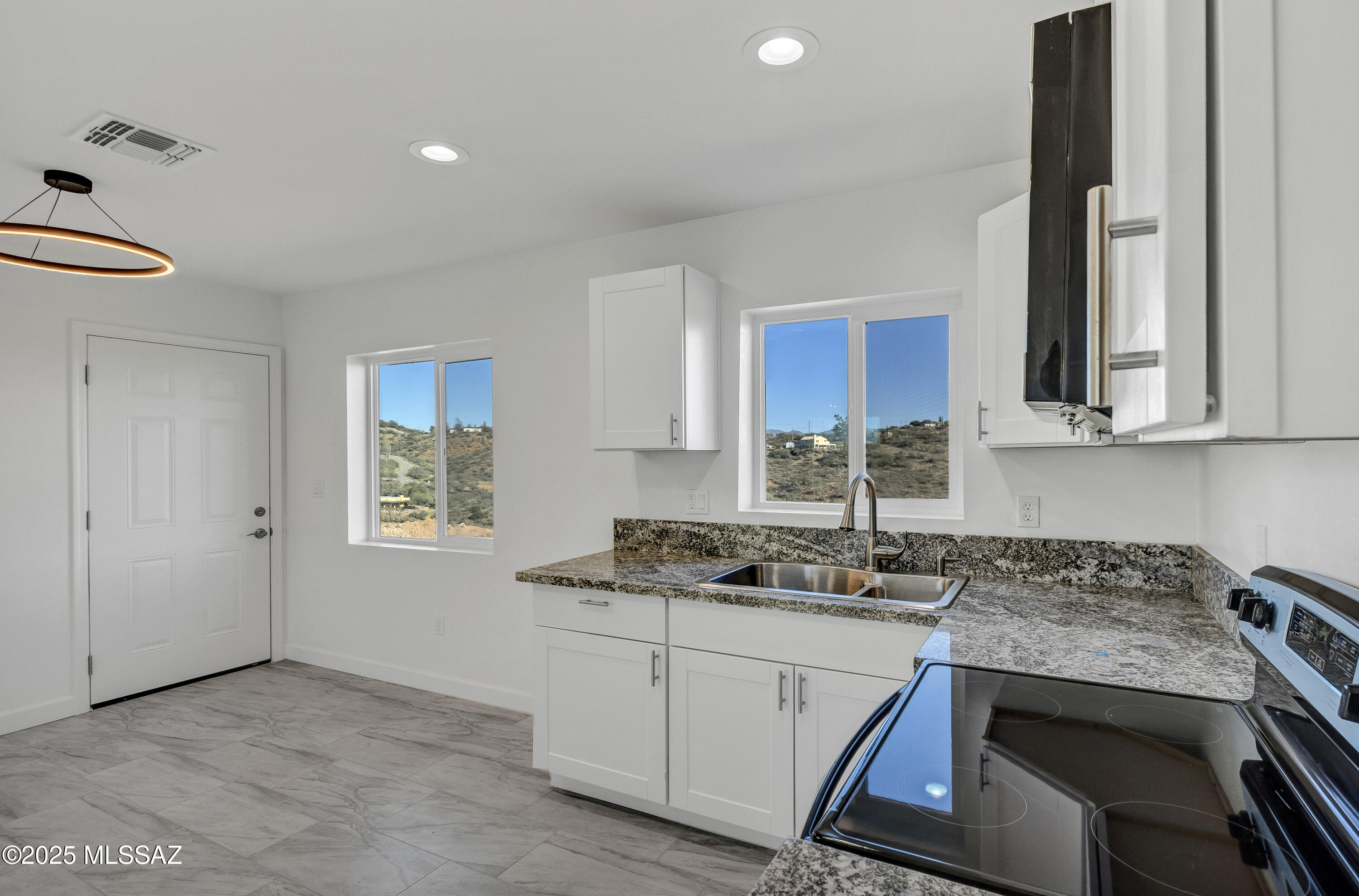 329 Camino Magnifico Rio Rico, AZ 85648 - Photo 10 of 47 a kitchen with stainless steel appliances granite countertop a sink stove and cabinets
