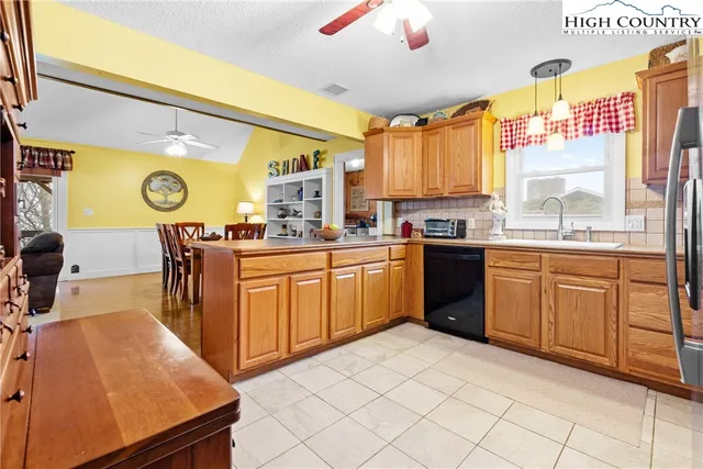 a kitchen with stainless steel appliances a sink window and cabinets