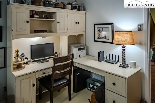 a view of a workspace with furniture and mirror