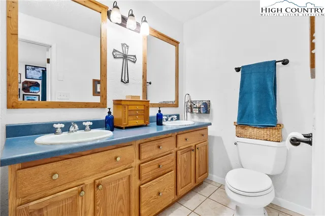 a bathroom with a granite countertop toilet sink and mirror