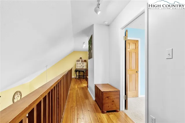 a view of a hallway with wooden floor and staircase
