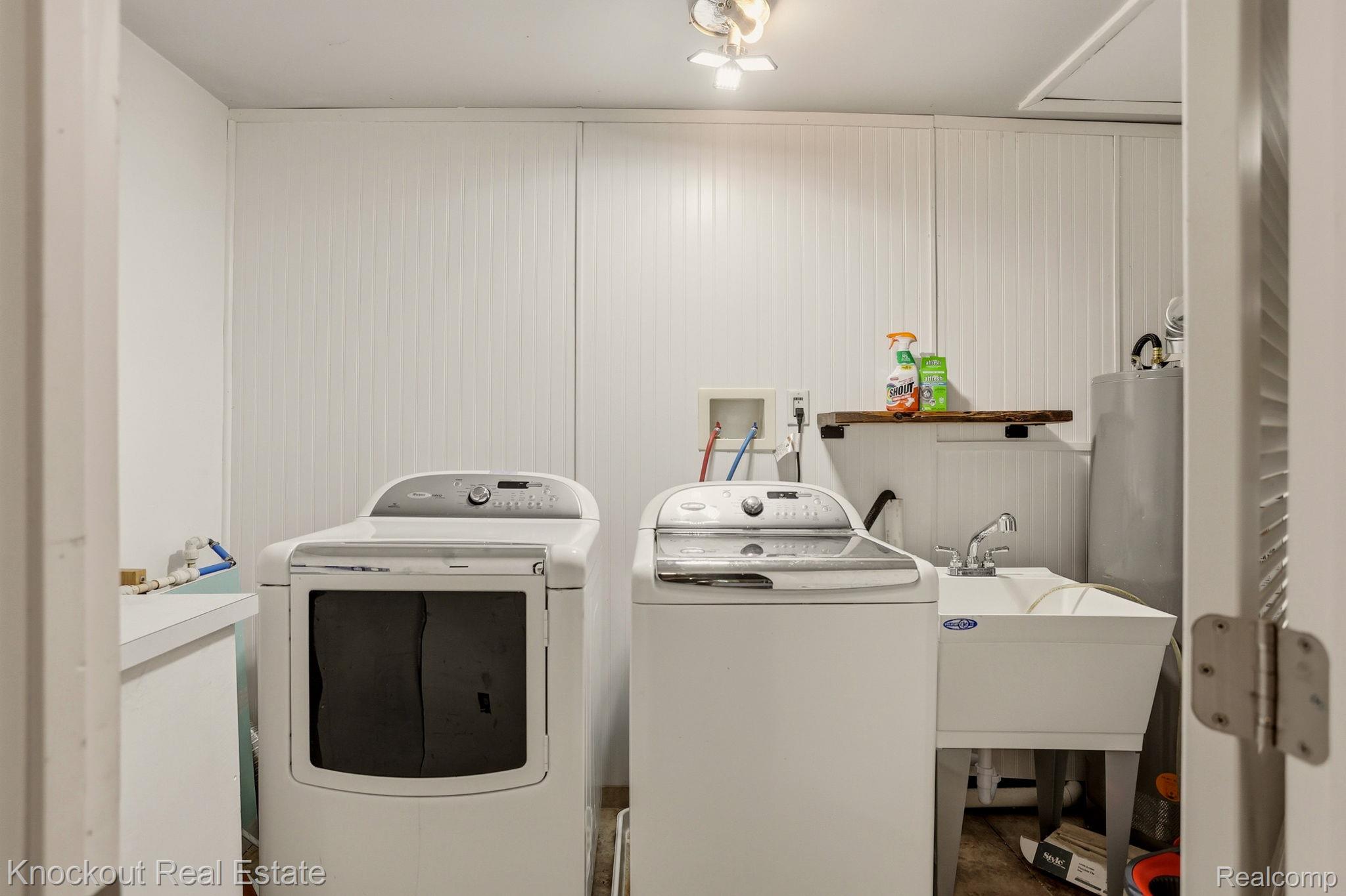 8845 Ormes Road Vassar, MI 48768 - Photo 16 of 35 Laundry area featuring a utility sink, vertical paneled walls, and a built-in shelf