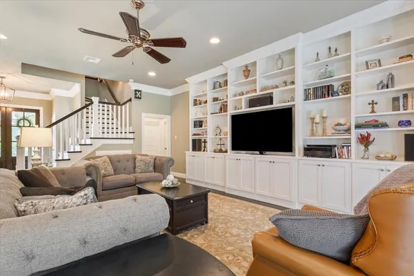 a living room with furniture ceiling fan and a flat screen tv