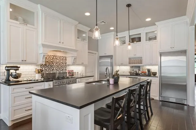 a kitchen with stainless steel appliances granite countertop a sink a stove and a refrigerator