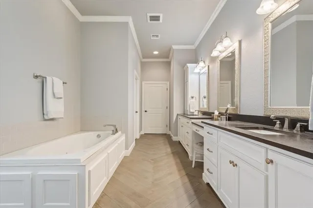 a spacious bathroom with a double vanity sink a mirror and a bathtub