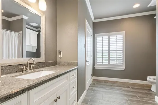 a bathroom with a granite countertop sink and a mirror