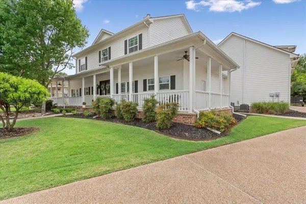 a front view of a house with a garden and plants