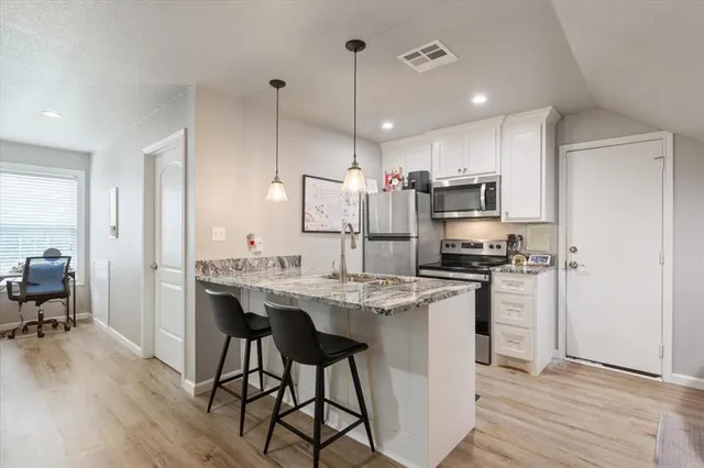 a kitchen with kitchen island a sink stove and refrigerator
