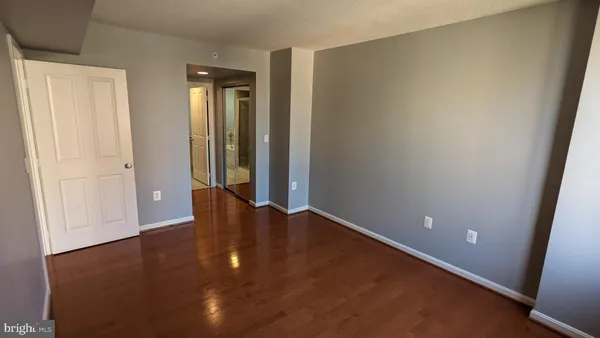 an empty room with wooden floor and closet