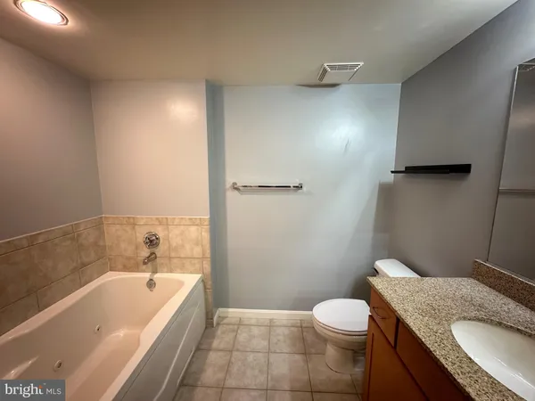 a bathroom with a granite countertop sink toilet and bathtub