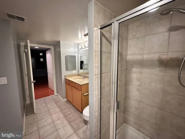 a bathroom with a granite countertop sink mirror and shower
