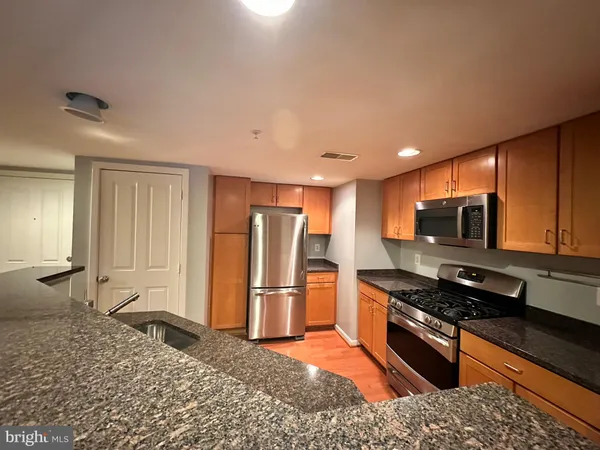 a kitchen with stainless steel appliances granite countertop a refrigerator stove and microwave