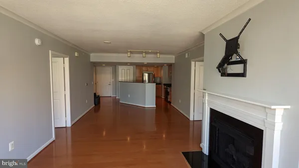 a view of a hallway with wooden floor and a fireplace