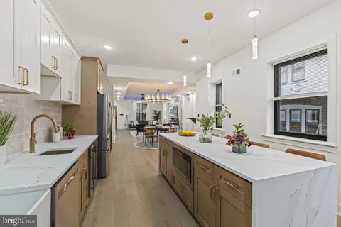 a kitchen with a sink a counter top space and stainless steel appliances