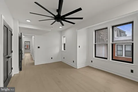 a view of an empty room with a window and a ceiling fan