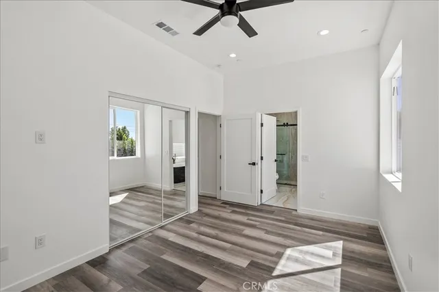 a view of a livingroom with wooden floor and a ceiling fan