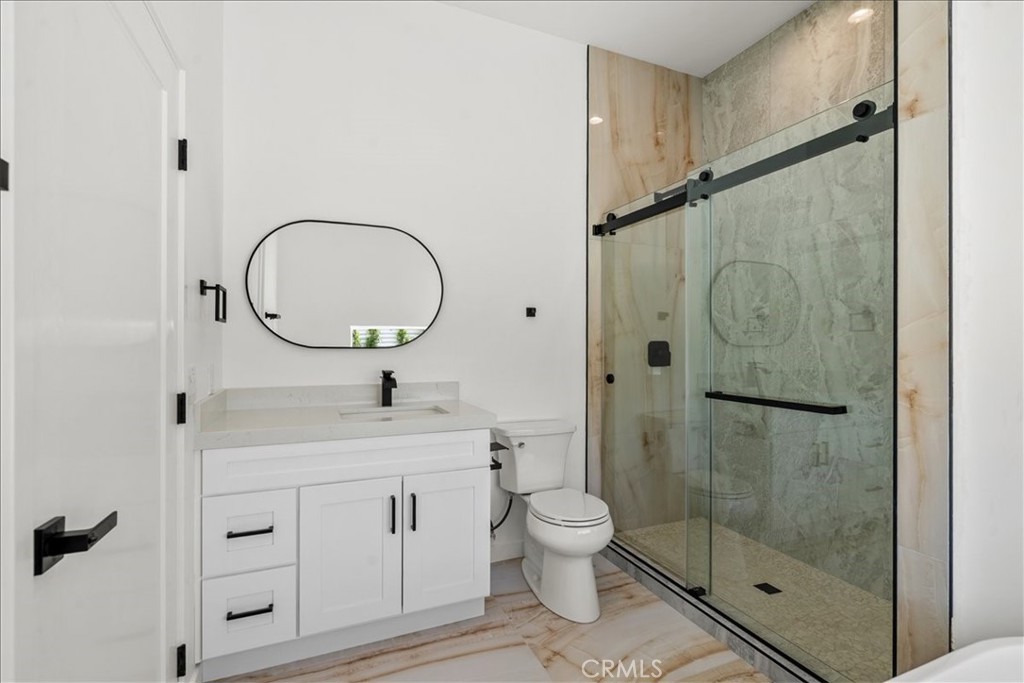 66423 San Marcus Road Desert Hot Springs, CA 92240 - Photo 16 of 28 a bathroom with a toilet sink vanity granite and shower