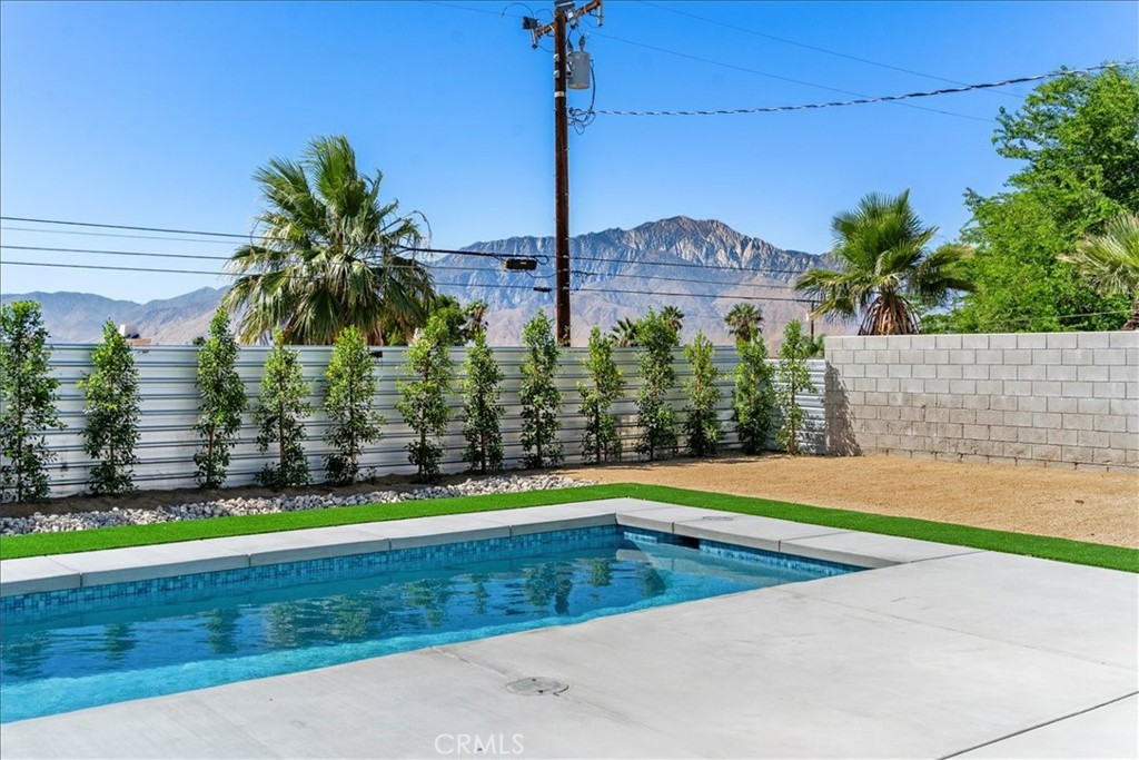 66423 San Marcus Road Desert Hot Springs, CA 92240 - Photo 2 of 28 a view of a swimming pool with a yard and palm trees