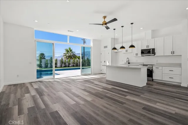 a open kitchen with kitchen island white cabinets and stainless steel appliances