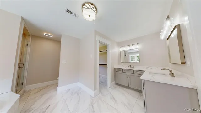 a spacious bathroom with a double vanity sink a mirror and a shower
