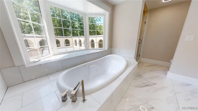 a bath tub sitting in a bathroom next to a window