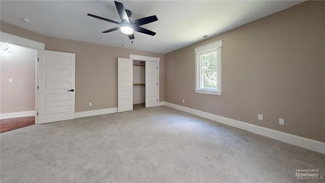 a view of a livingroom with a ceiling fan and window