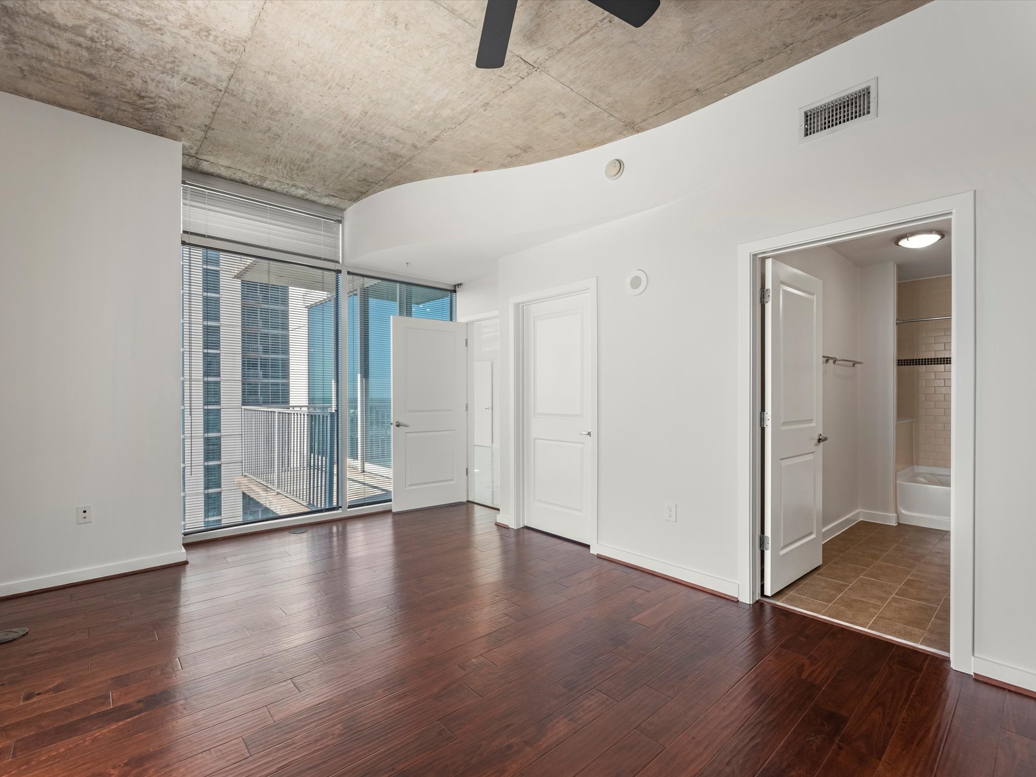 5925 Almeda Road, Unit 11702 Houston, TX 77004 - Photo 11 of 35 an empty room with wooden floor and windows