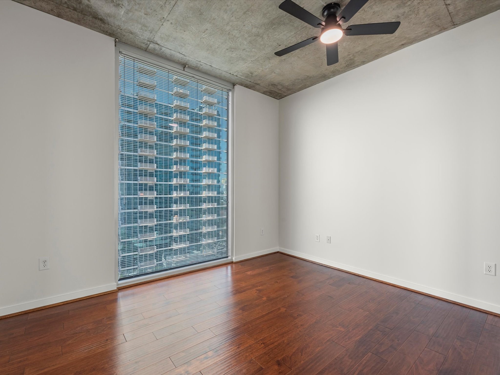 5925 Almeda Road, Unit 11702 Houston, TX 77004 - Photo 15 of 35 a view of an empty room with a window and wooden floor