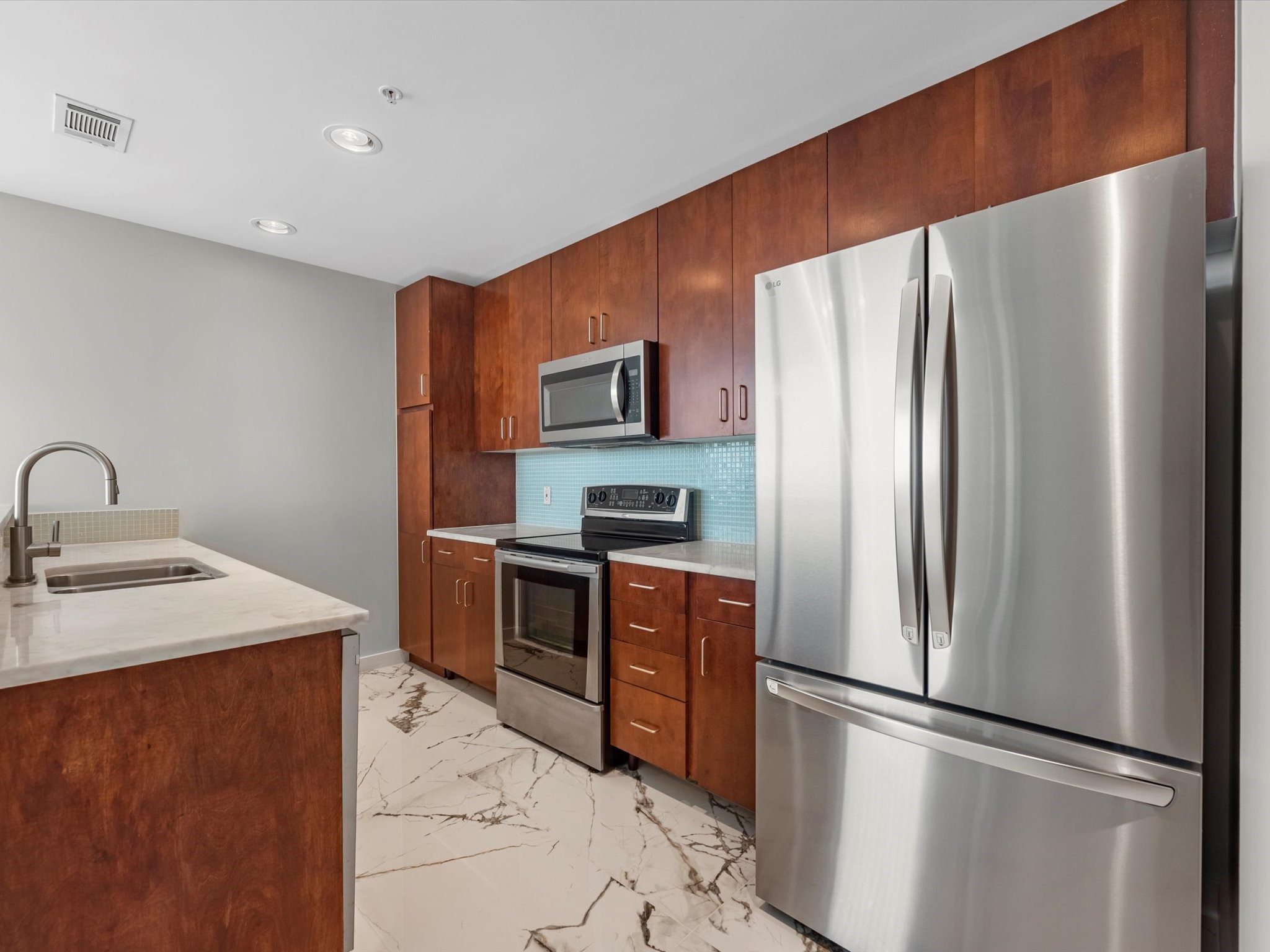5925 Almeda Road, Unit 11702 Houston, TX 77004 - Photo 5 of 35 a kitchen with stainless steel appliances granite countertop a refrigerator and a stove top oven