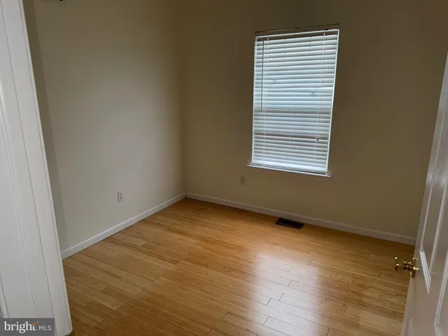 an empty room with wooden floor and a window