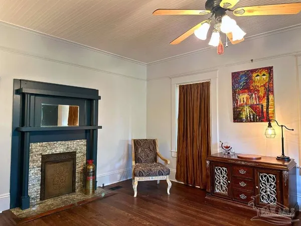 a living room with furniture a fireplace and a chandelier