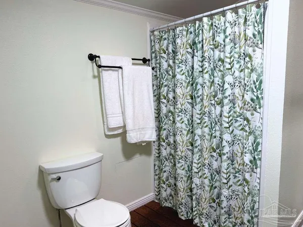 a white toilet sitting next to a shower curtain