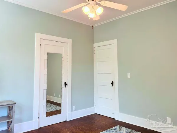 a view of a hallway with wooden floor and closet