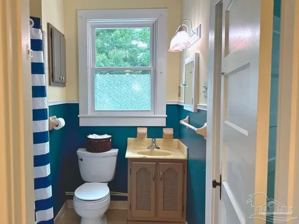 a bathroom with a toilet sink and mirror