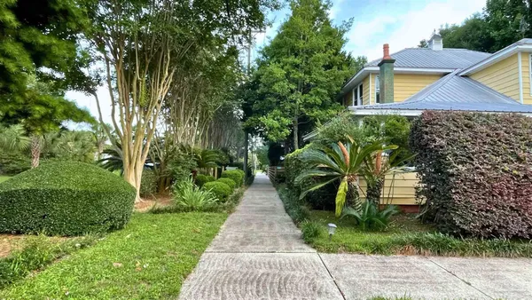 a pathway of a house with a yard