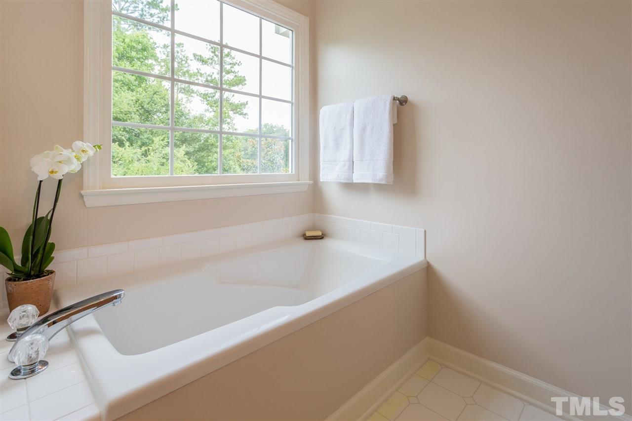 3225 Sandy Bluff Road Raleigh, NC 27616 - Photo 18 of 25 a white bath tub sitting in a bathroom next to a window
